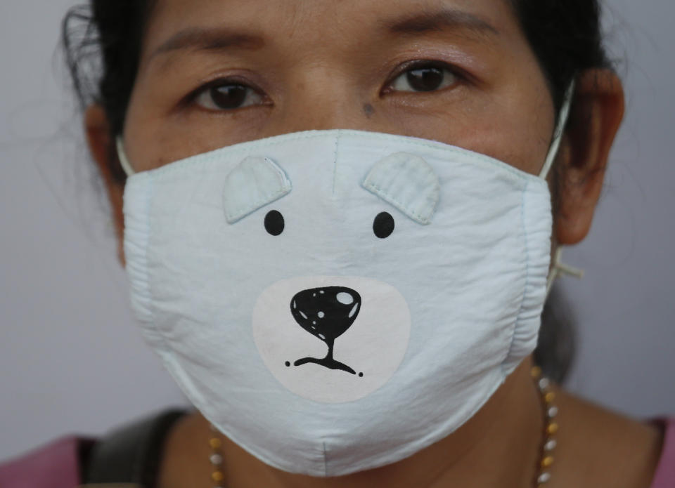 A woman wears a protective mask while waiting for a bus during smoggy conditions in Bangkok, Thailand, Monday, Jan. 14, 2019. Unusually high levels of smog worsened by weather patterns are raising alarm across Asia. (AP Photo/Sakchai Lalit)
