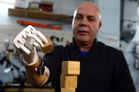 Sergey Galtsev adds cubes during the testing of a prosthetic right hand, made by his son Oleg, in Minsk, Belarus October 16, 2016. REUTERS/Vasily Fedosenko