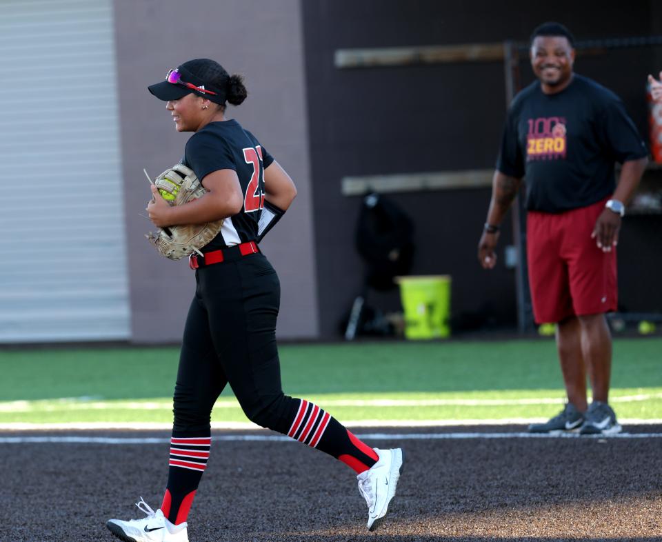 Yukon's Ariah Mitchell runs onto the field in front of her father, Putnam North coach D'Antae Mitchell, during Thursday's softball game in Yukon.