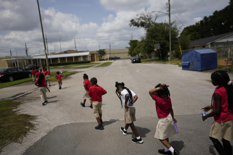 A student adjusts her uniform as a class from Thomas Leadership Academy files back toward the school building after playing on the playground in Eatonville, Fla., Wednesday, Aug. 23, 2023. (AP Photo/Rebecca Blackwell)