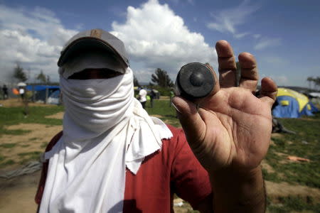 A protesting migrant displays a rubber bullet he says was fired by Macedonian police during clashes at a makeshift camp for refugees and migrants at the Greek-Macedonian border near the village of Idomeni, Greece, April 10, 2016. REUTERS/Alexandros Avramidis