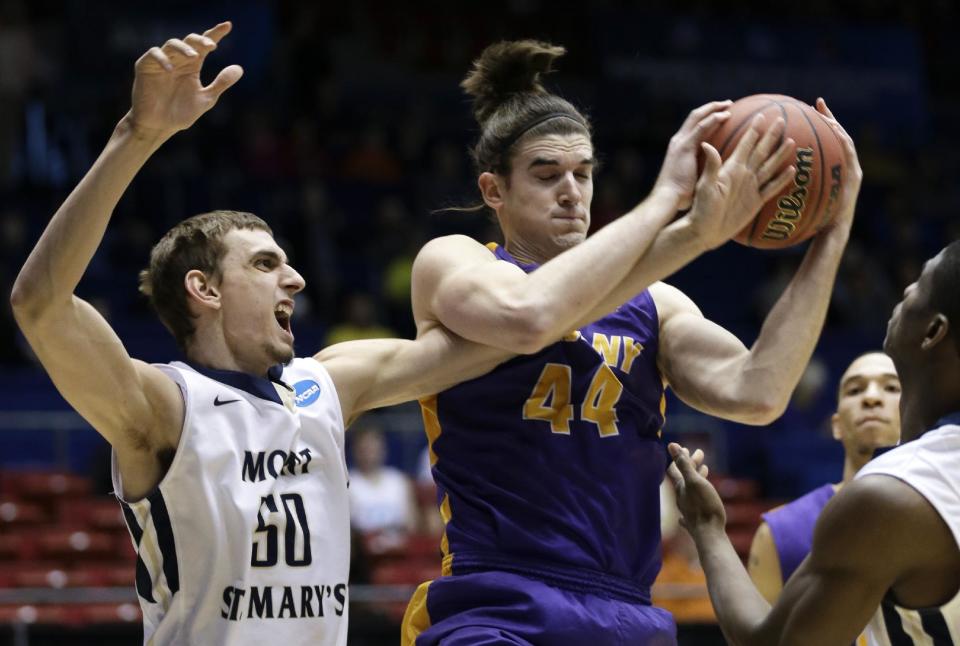 Albany center John Puk (44) pulls a rebound away from Mount St. Mary's center Taylor Danaher (50) in the first half of a first-round game of the NCAA college basketball tournament, Tuesday, March 18, 2014, in Dayton, Ohio. (AP Photo/Al Behrman)