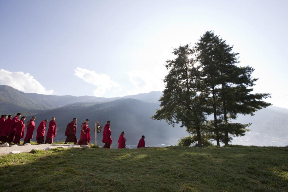 Novice monks at the Dechen Phrodrang Buddhist monastery walk down a hillside to have breakfast in Bhutan's capital Thimphu