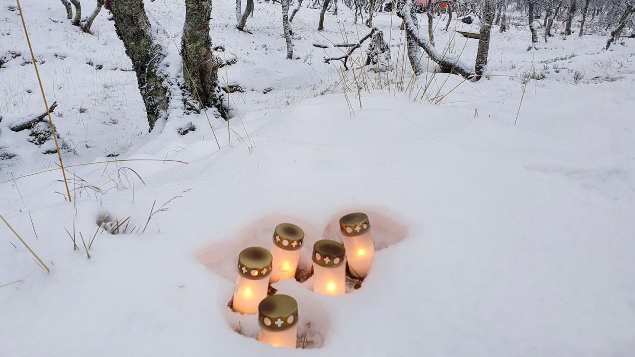 Brennende Kerzen sind im Schnee in der Nähe des Ortes nach einen Hüttenbrand in Norwegen aufgestellt worden.