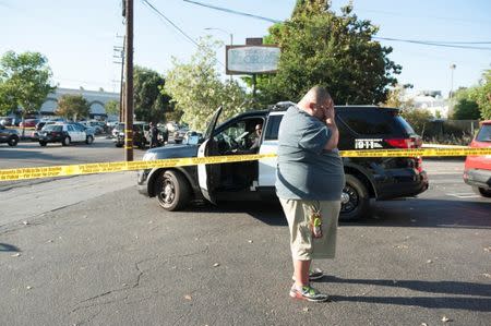 A Trader Joe's employee waits in a parking lot near a Trader Joe's store where a hostage situation unfolded in Los Angeles, California, July 21, 2018. REUTERS/Andrew Cullen