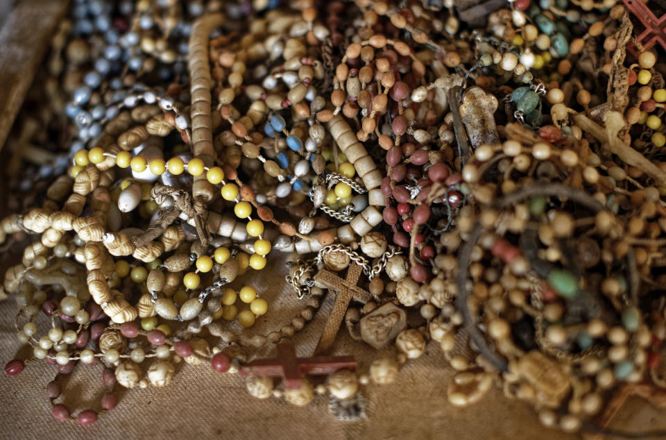 A pile of necklaces and crucifixes belonging to some of those who were slaughtered as they sought refuge inside the church sit on the altar as a memorial to the thousands who were killed during the 1994 genocide in and around the Catholic church in Nyamata, Rwanda Thursday, April 4, 2019. Rwanda will commemorate on Sunday, April 7, 2019 the 25th anniversary of when the country descended into an orgy of violence in which some 800,000 Tutsis and moderate Hutus were massacred by the majority Hutu population over a 100-day period in what was the worst genocide in recent history. (AP Photo/Ben Curtis)