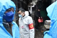 Man returns to his house with food delivered by volunteers at a residential area in Wuhan