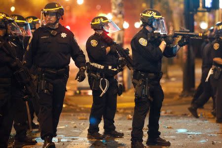 Police officers try to disperse a crowd in San Francisco, California October 29, 2014. REUTERS/Stephen Lam