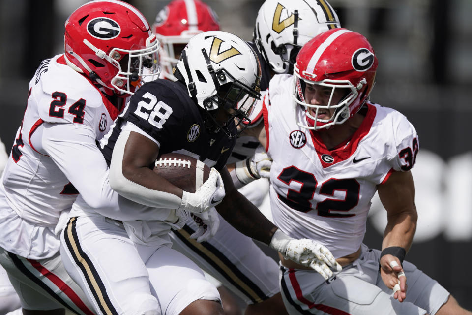 Georgia defensive back Malaki Starks (24) and linebacker Chaz Chambliss, right, tackle Vanderbilt running back Sedrick Alexander (28) in the second half of an NCAA college football game Saturday, Oct. 14, 2023, in Nashville, Tenn. (AP Photo/George Walker IV)