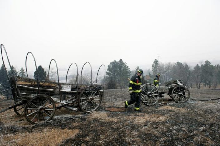 On Dec 31, 2021 firefighters walk near a home destroyed by a wildfire in Boulder County, Colorado (AFP/Jason Connolly)