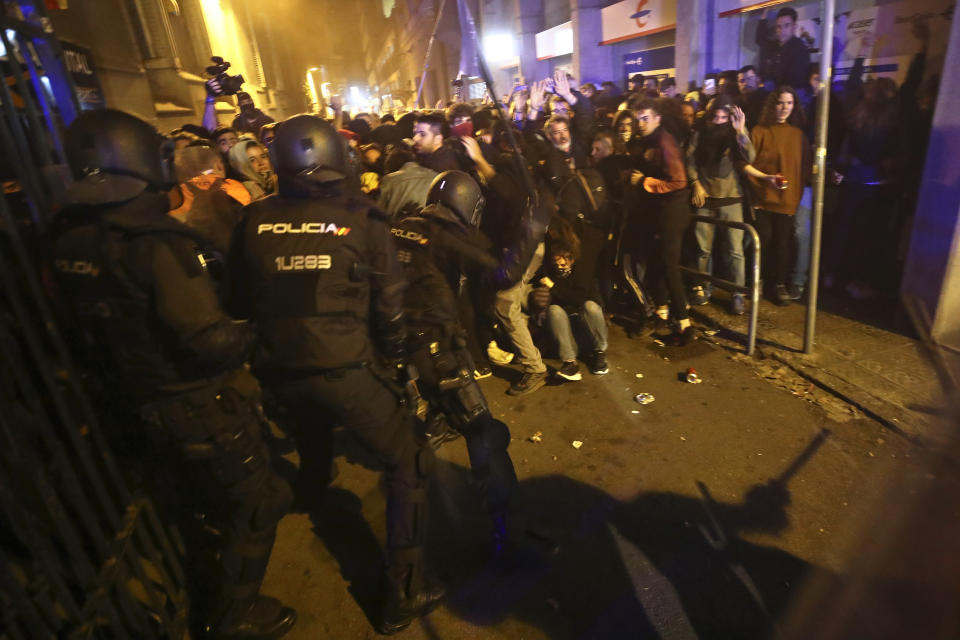 Policemen in riot gear charge against protestors in Barcelona, Spain, Tuesday, Oct. 15, 2019. Spain's Supreme Court on Monday convicted 12 former Catalan politicians and activists for their roles in a secession bid in 2017, a ruling that immediately inflamed independence supporters in the wealthy northeastern region. (AP Photo/Emilio Morenatti)