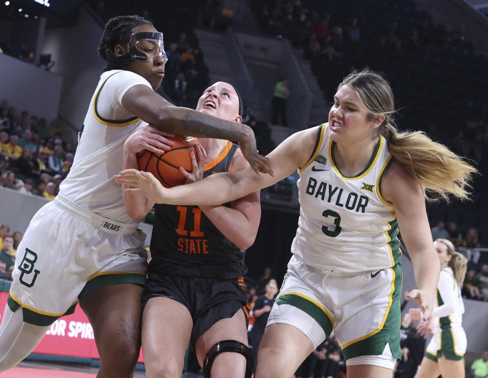 Oklahoma State guard Rylee Langerman is pressured by Baylor forward Dre'Una Edwards, left, and forward Madison Bartley, right, in the first half of an NCAA college basketball game, Sunday, March 3, 2024, in Waco, Texas. (Rod Aydelotte/Waco Tribune-Herald via AP)