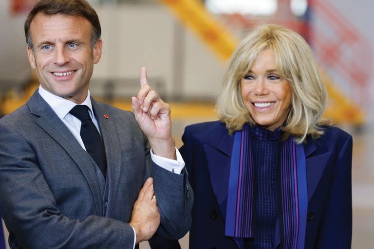 El presidente francés Emmanuel Macron y su esposa Brigitte Macron sonríen durante su visita a la planta de Airbus en Hamburgo, en el norte de Alemania, el 9 de octubre de 2023.