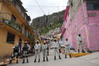 FILE - A National Guard patrol stand guard on the perimeters of a landslide that brought tons of massive boulders down on a steep hillside neighborhood, in Tlalnepantla, on the outskirts of Mexico City, Sept. 11, 2021. Mexico’s President Andres Manuel Lopez Obrador has begun exploring plans to side-step congress to hand formal control of the National Guard to the army. That has raised concerns, because Lopez Obrador won approval for creating the force in 2019 by pledging in the constitution that it would be under nominal civilian control and that the army would be off the streets by 2024. (AP Photo/Ginnette Riquelme)