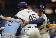 Milwaukee Brewers' Abner Uribe (45) is held back by Quintin Berry (33) as he fights with Tampa Bay Rays' Jose Siri (22) during the eighth inning of a baseball game Tuesday, April 30, 2024, in Milwaukee. (AP Photo/Aaron Gash)