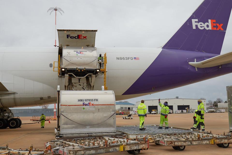 FedEx Express employees help load up a cargo jet with Johnson & Johnson COVID-19 vaccine doses at the FedEx Express World Hub in Memphis, Tennessee on March 1, 2021.