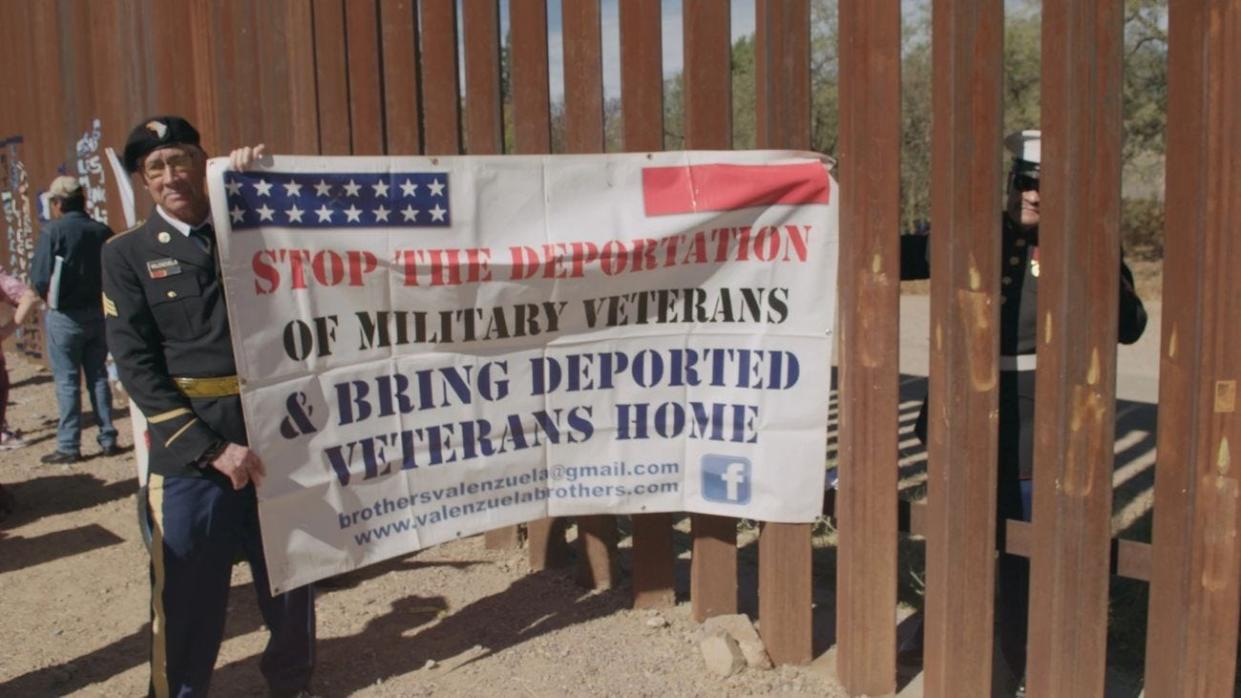 Valente Valenzuela, U.S. Army veteran, stands on Mexico's side of the U.S.-Mexico border with his brother, Manuel, on the U.S. side, protesting veteran deportations.