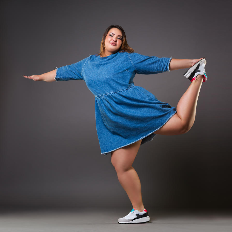 Plus size fashion model in casual clothes, fat woman on gray background, overweight female body, full length portrait