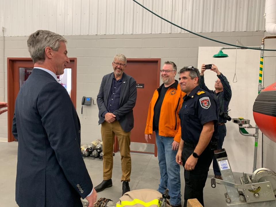 Premier Tim Houston speaks with emergency management minister John Lohr, Ashley Perry of Valley Search and Rescue and Canning Volunteer Fire Department Chief Jeff Skaling during a funding announcement on Tuesday.