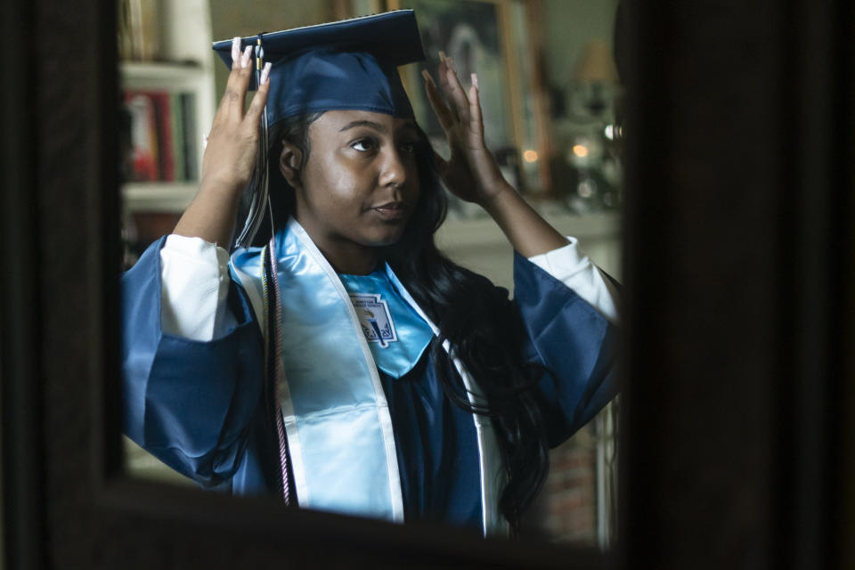 Nylla Miller, reflected in a mirror, prepares for her high school graduation ceremony at her home in Aldan, Pa., Thursday, June 15, 2023. (AP Photo/Matt Rourke)