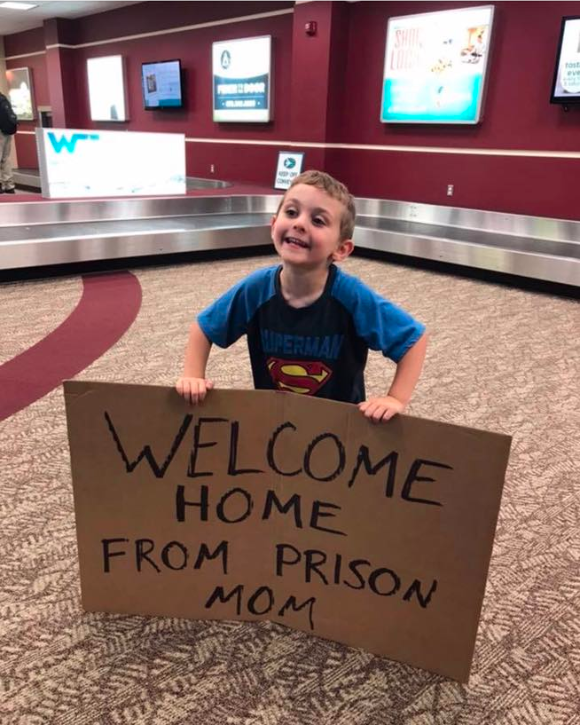 A mum returning from a business trip was left a little mortified after she saw what sign her son was holding.