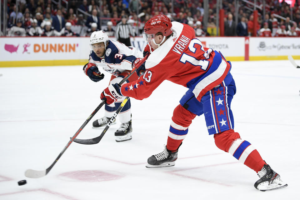 Washington Capitals left wing Jakub Vrana (13), of the Czech Republic, shoots the puck next to Columbus Blue Jackets defenseman Seth Jones (3) during the first period of an NHL hockey game, Monday, Dec. 9, 2019, in Washington. (AP Photo/Nick Wass)