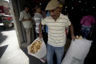 En esta imagen, tomada el 17 de marzo de 2017, un empleado de la panadería estatal Minka carga bolsas con pan para su distribución en tiendas estatales, en Caracas, Venezuela. Agentes de la Superintendencia Nacional para la Defensa de los Derechos Socioeconómicos (Sundde) irrumpieron en Mansion’s Bakery la semana pasada y acusaron a los encargados de la panadería de acaparar la harina que les da el gobierno y que las autoridades exigen se use para elaborar pan y no productos más caros como pastelillos. (AP Foto/Fernando Llano)