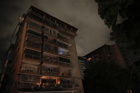 A man stands at the balcony of his apartment as he waits for the power to return after a blackout in Caracas December 2, 2013. REUTERS/Carlos Garcia Rawlins