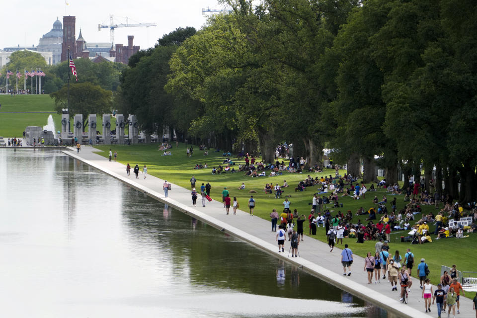 People walk along the reflecting pool during the 60th Anniversary of the March on Washington at the Lincoln Memorial in Washington, Saturday, Aug. 26, 2023. (AP Photo/Andrew Harnik)