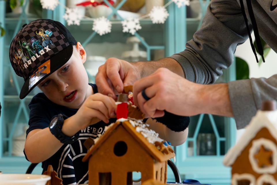 Darin Priday, right, helps his son Zeke, 8, rebuild his fallen gingerbread house at their home in Saratoga Springs on Sunday, Dec. 3, 2023. | Megan Nielsen, Deseret News