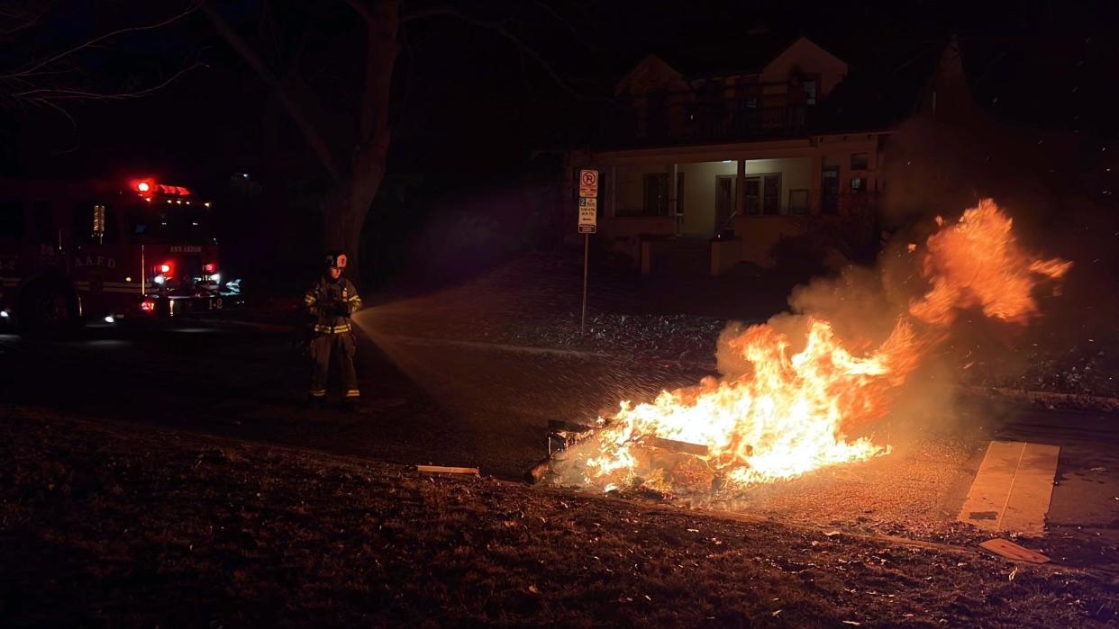 An Ann Arbor firefighter extinguishes a mattress fire at the corner of Cambridge Road and Olivia Avenue in Ann Arbor after Michigan beat the Washington Huskies in the College Football Playoff national championship on Mon., Jan. 8, 2024.