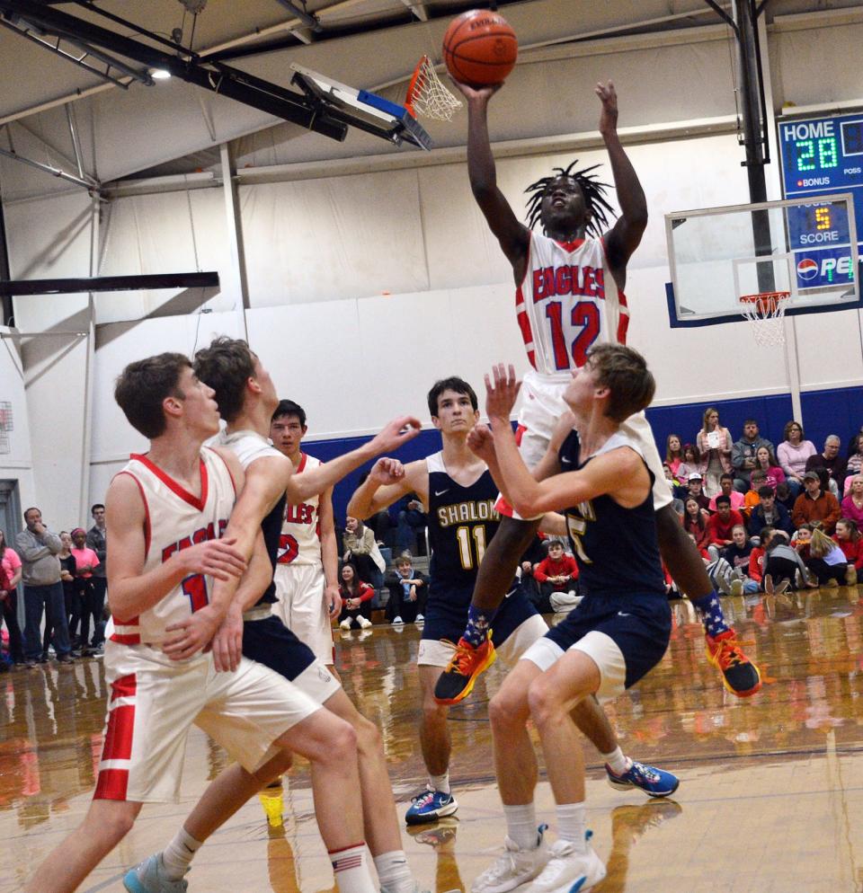 Heritage's Sean Mongan (12) takes a shot in the lane against Shalom during the Mason Dixon Christian Conference boys basketball championship game last winter.