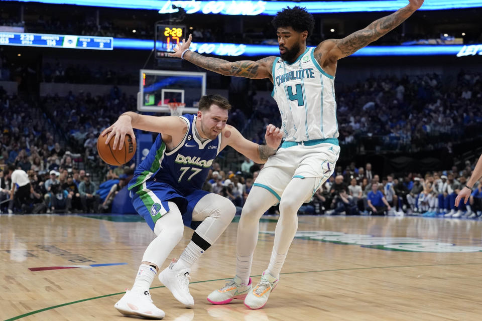 Dallas Mavericks guard Luka Doncic (77) tries to get around Charlotte Hornets center Nick Richards (4) during the second half of an NBA basketball game in Dallas, Friday, March 24, 2023. (AP Photo/LM Otero)