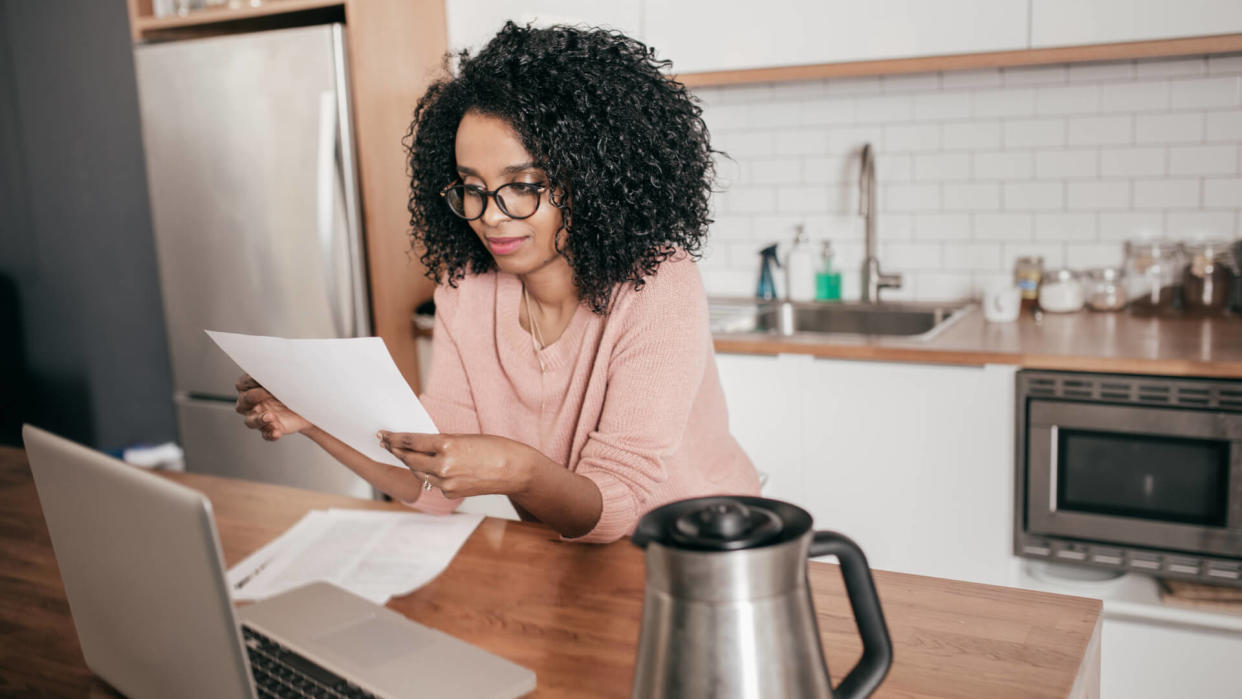 Woman taking care of finances at kitchen counter