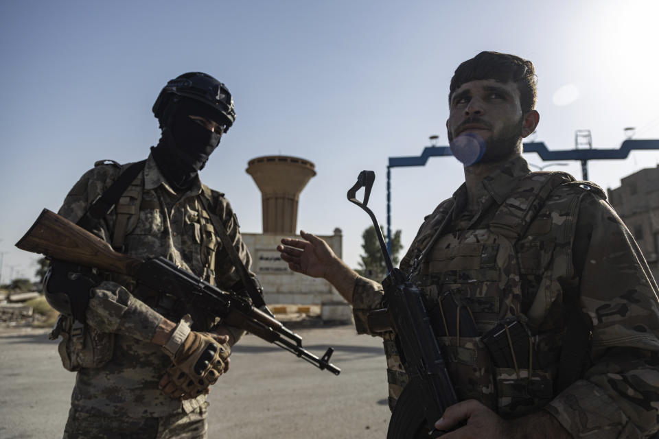 U.S.-backed Syrian Democratic Forces (SDF) fighters stand guard on a street at al-Baseera town, in the eastern countryside of Deir el-Zour, Syria, Monday, Sept. 4, 2023. Weeklong clashes between rival U.S.-backed militias in eastern Syria, where hundreds of American troops are deployed, point to dangerous seams in a coalition that has kept on a lid on the defeated Islamic State group for years. (AP Photo/Baderkhan Ahmad)