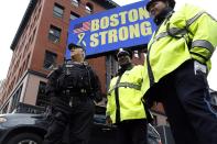 Boston Police stand beneath a Boston Strong sign near the site of one of the two bomb blasts on the one-year anniversary of the 2013 Boston Marathon bombings in Boston, Massachusetts, April 15, 2014. REUTERS/Dominick Reuter (UNITED STATES - Tags: SOCIETY DISASTER)
