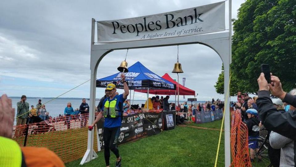 Birch Equipment’s team kayaker is first to ring the bell at Marine Park in Fairhaven during the Ski to Sea race on Sunday, May 29, 2022, in Whatcom County, Wash.