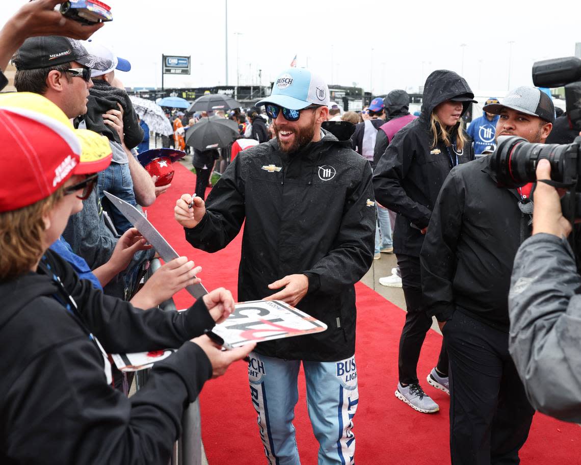 Ross Chastain, center, was one of a number of NASCAR Cup Series drivers who signed autographs for fans during a pre-race rain delay at Kansas Speedway on Sunday. Reese Strickland/USA TODAY Sports
