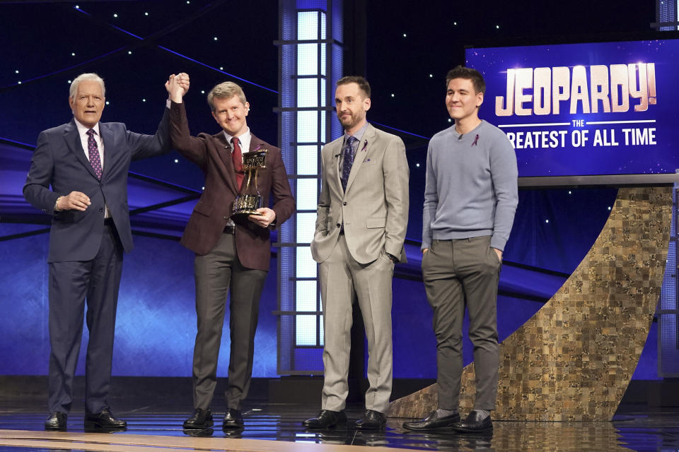 This image released by ABC shows host Alex Trebec, left, joining hands with contestant Ken Jennings after he won "JEOPARDY! The Greatest of All Time," as fellow contestants Brad Rutter and James Holzhauer look on. Jennings won the $1 million prize in the tournament that stretched out over four entertaining nights on ABC's prime-time schedule. (Eric McCandless/ABC via AP)