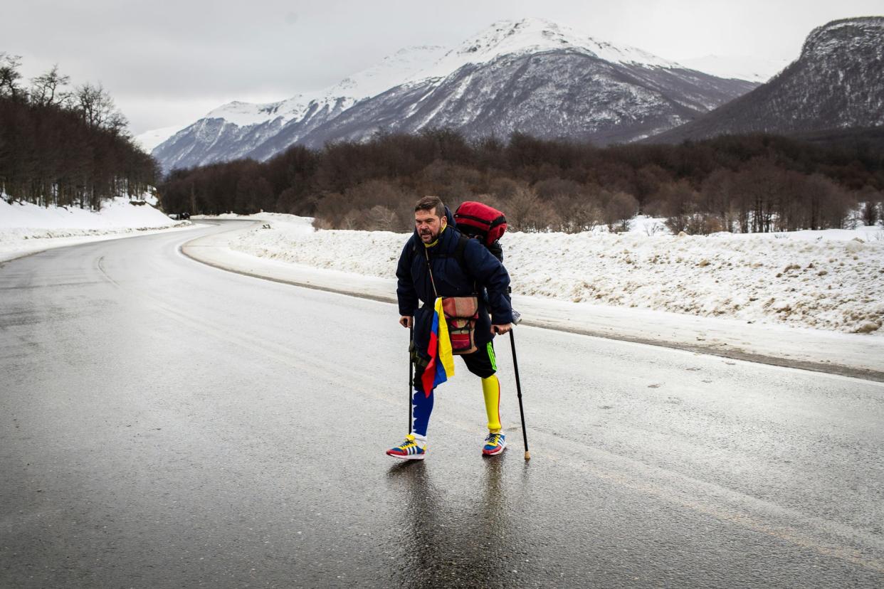 Venezuelan Yeslie Aranda walks on Route 3 between Tolhuin and Ushuaia, Argentina, Saturday, Aug. 17, 2019. Aranda left his hometown of San Cristobal last year with a backpack, $30 in his pocket and an aluminum prosthesis that enabled him to negotiate rugged roads.