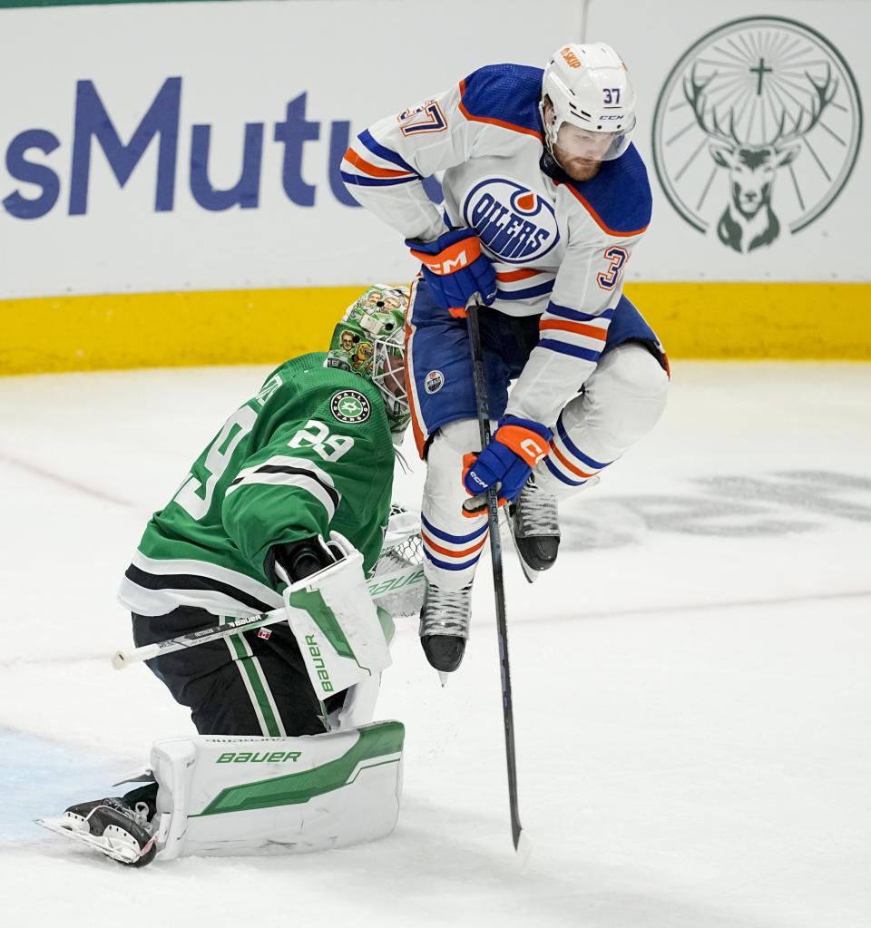 Dallas Stars goaltender Jake Oettinger (29) makes a save as Edmonton Oilers left wing Warren Foegele (37) applies a screen during overtime in Game 1 of the NHL hockey Western Conference Stanley Cup playoff finals, Thursday, May 23, 2024, in Dallas. (AP Photo/Tony Gutierrez)