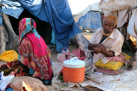 People sit outside their hut at a camp sheltering displaced people from the Red Sea port city of Hodeidah near Aden, Yemen November 12, 2018. Pictures taken November 12, 2018. REUTERS/Fawaz Salman