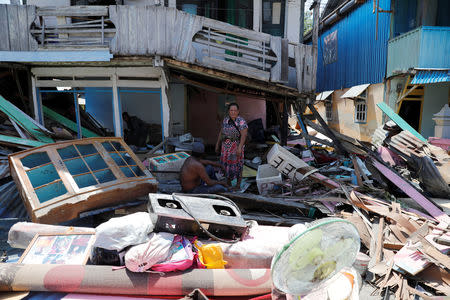 Residents sit in front of their house after being hit by tsunami at Wani village in Donggala regency, Sulawesi island, Indonesia, October 2, 2018. REUTERS/Beawiharta