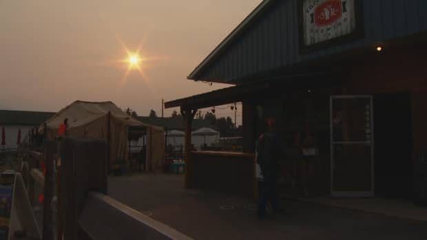 People enter the local brewery under smoky skies in Valemount, B.C., in early July 2021.  (Michael McArthur/CBC - image credit)