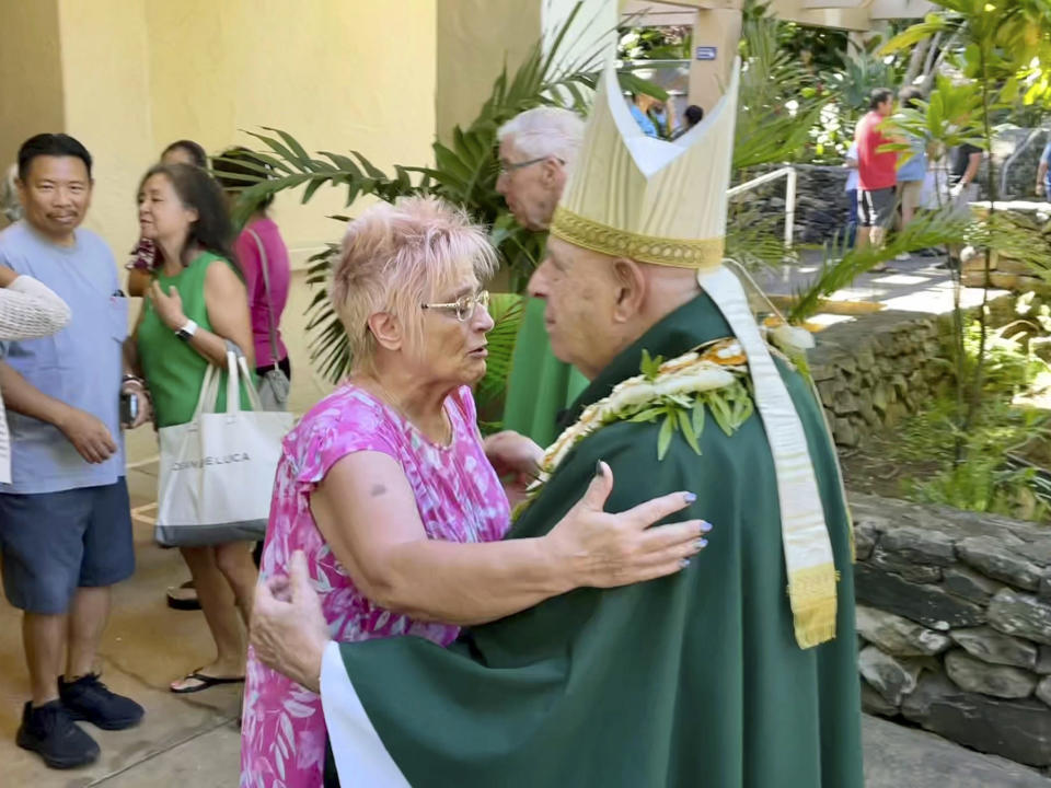 Most Rev. Clarence "Larry" Silva, the Bishop of Honolulu, greets a parishioner after Mass at Sacred Hearts Mission Church in Kapalua, Hawaii, Sunday, Aug. 13, 2023. Sacred Hearts Mission Church hosted congregants from Maria Lanakila Catholic Church in Lahaina, including several people who lost family members in fires that burned most of the Maui town days earlier. (AP Photo/Haven Daley)