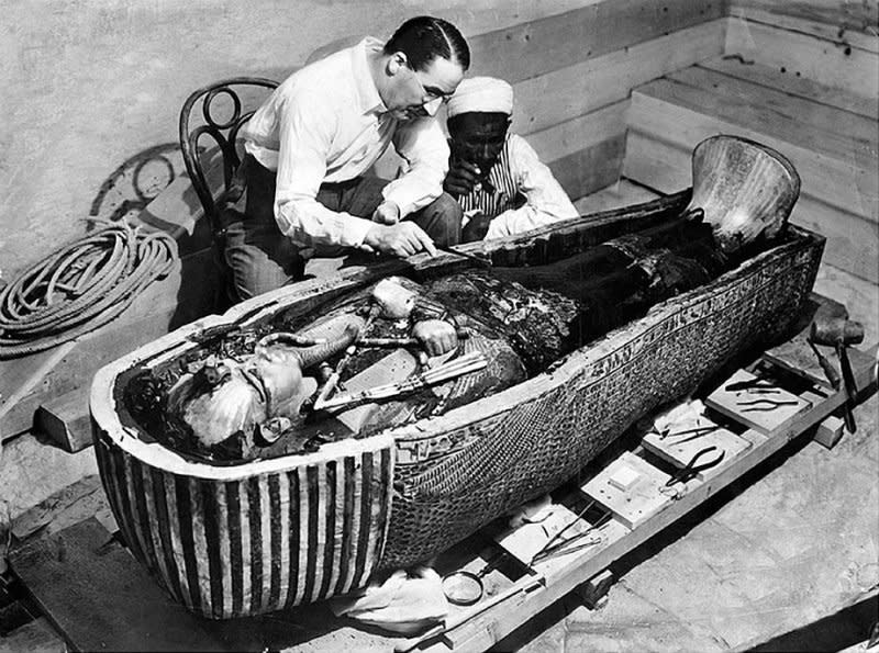 Howard Carter examines the innermost coffin belonging to Egyptian Pharaoh Tutankhamun in 1925. On January 3, 1924, two years after rediscovering the tomb of King Tut in Egypt, Carter and his workers found the stone sarcophagus that contained the gold coffin and mummy of the boy king. File Photo courtesy of Wikimedia