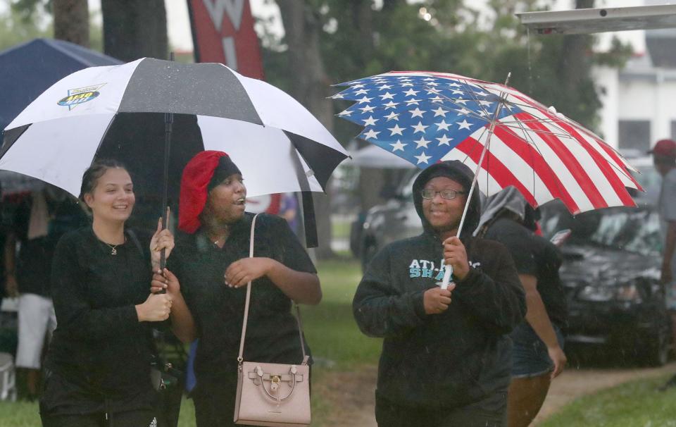 Juneteenth-event attendees try to keep dry in Daytona Beach on June 17. The region, to date, has received more than 4.5 inches of rain.