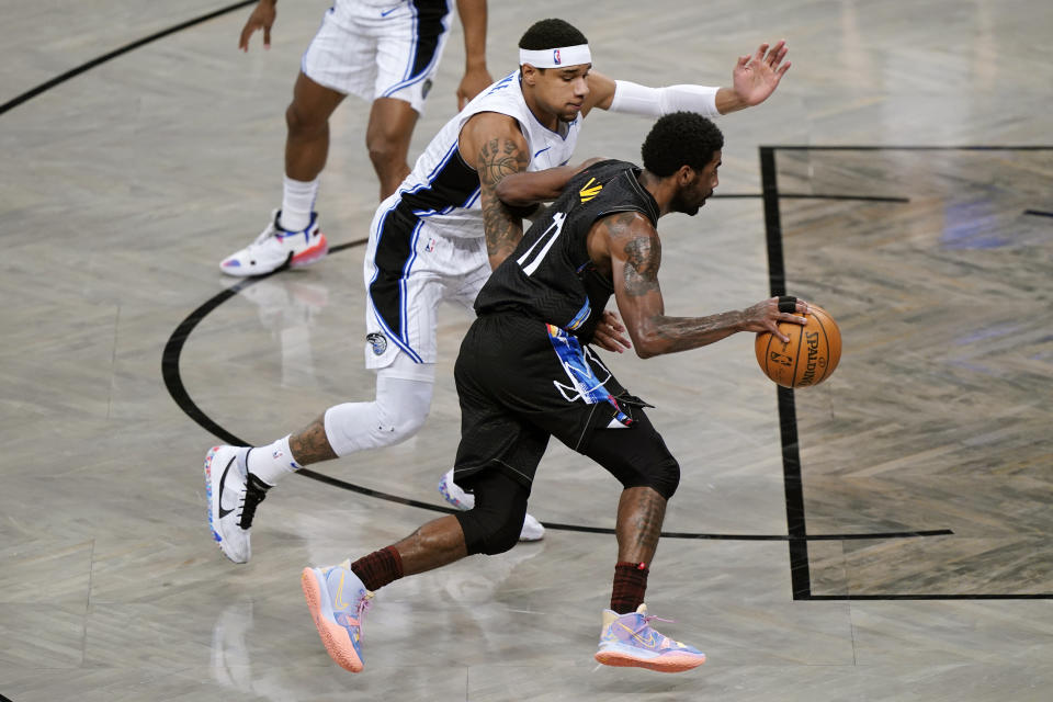 Orlando Magic forward Chuma Okeke, front left, defends against Brooklyn Nets guard Kyrie Irving (11) as Irving drives to the basket during the second quarter of an NBA basketball game, Thursday, Feb. 25, 2021, in New York. (AP Photo/Kathy Willens)