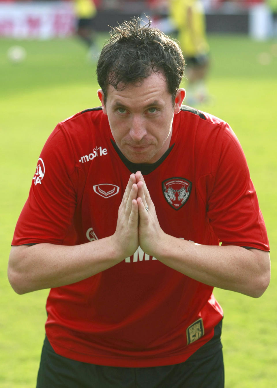 FILE - In this July 10, 2011, file photo, former England national team and Liverpool striker Robbie Fowler greets fans at Muangthong United soccer club on the outskirts of Bangkok, Thailand. Fowler has made more headlines and waves since his arrival for the 2020-21season as a coach in the Indian Super League (ISL) than his more experienced counterparts on the subcontinent. (AP Photo/Apichart Weerawong, FILE)