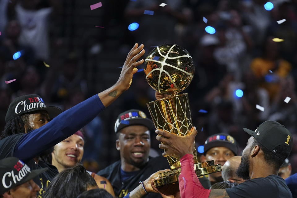 Denver Nuggets players hold up the Larry O'Brien NBA Championship Trophy after their victory over the Miami Heat in Game 5 of basketball's NBA Finals, Monday, June 12, 2023, in Denver. (AP Photo/Jack Dempsey)